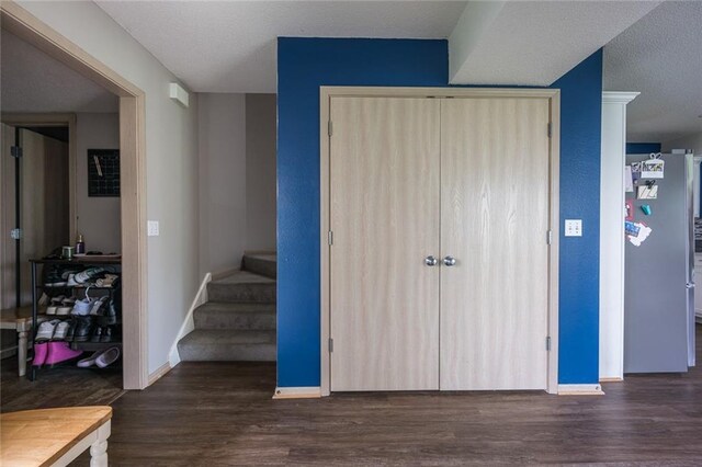 8008 NE Elmwood Ave, Kansas City, MO 64119 - staircase featuring wood finished floors, baseboards, and a textured ceiling