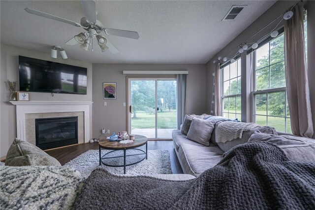8008 NE Elmwood Ave, Kansas City, MO 64119 - living area with a textured ceiling, wood finished floors, ceiling fan, and a tile fireplace