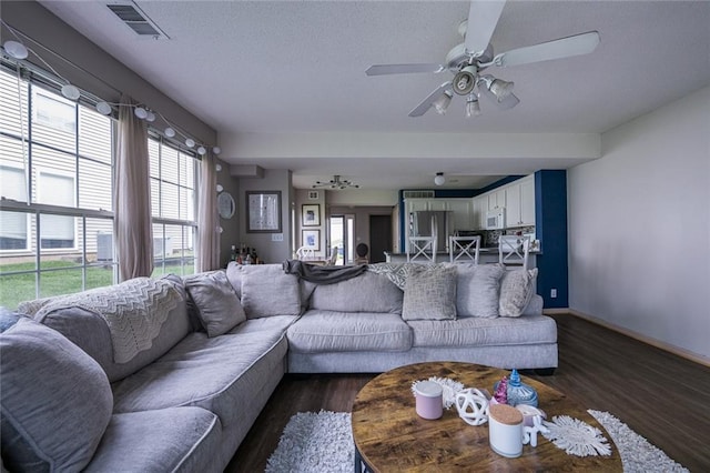 8008 NE Elmwood Ave, Kansas City, MO 64119 - living room featuring dark wood finished floors, ceiling fan, baseboards, and a textured ceiling