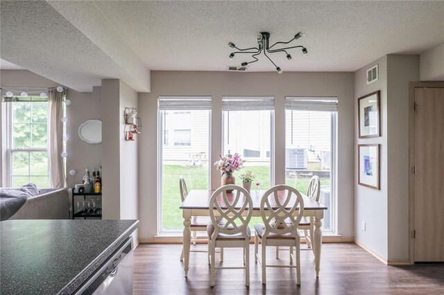 8008 NE Elmwood Ave, Kansas City, MO 64119 - dining space with a textured ceiling, wood finished floors, and baseboards