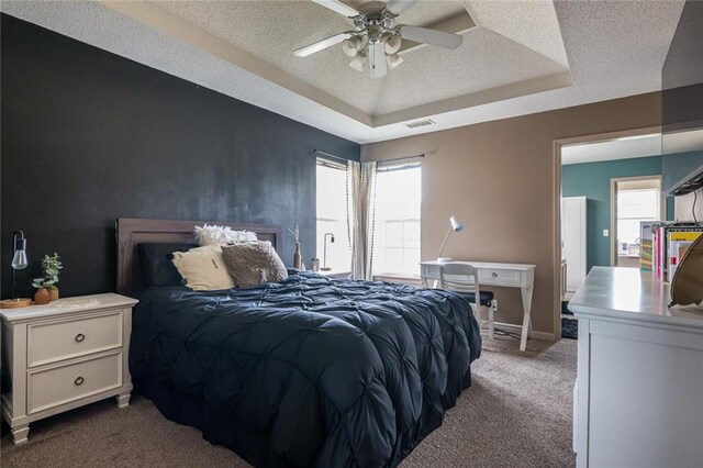 8008 NE Elmwood Ave, Kansas City, MO 64119 - bedroom with carpet floors, a raised ceiling, multiple windows, a textured ceiling, and a ceiling fan