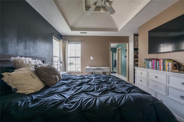 8008 NE Elmwood Ave, Kansas City, MO 64119 - bedroom with a tray ceiling, a textured ceiling, and ceiling fan