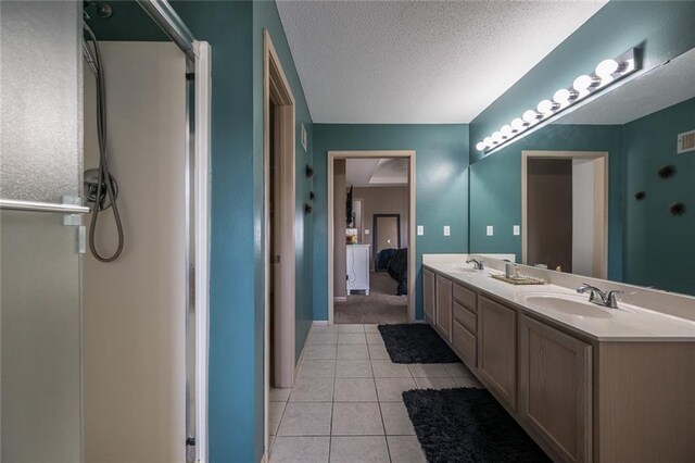 8008 NE Elmwood Ave, Kansas City, MO 64119 - bathroom featuring double vanity, tile patterned flooring, and a textured ceiling