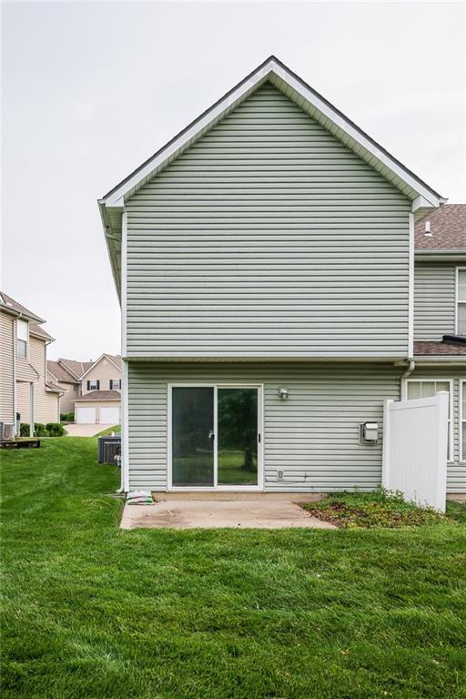 8008 NE Elmwood Ave, Kansas City, MO 64119 - rear view of house with a yard, a patio, and central AC