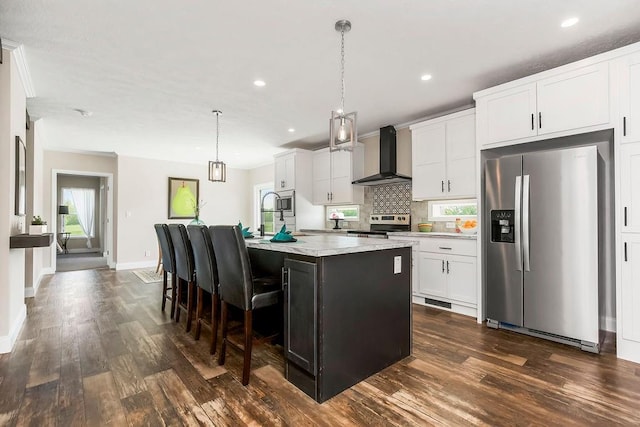 85 Birdie Ln, Mound City, KS 66056 - kitchen with stainless steel appliances, wall chimney exhaust hood, dark wood-style floors, a center island with sink, and white cabinetry