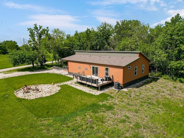 85 Birdie Ln, Mound City, KS 66056 - back of property with a fire pit, a wooden deck, central AC unit, and a lawn