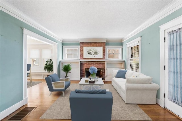 18 W 61st Ter, Kansas City, MO 64113 - living area featuring a textured ceiling, crown molding, a fireplace, wood finished floors, and baseboards