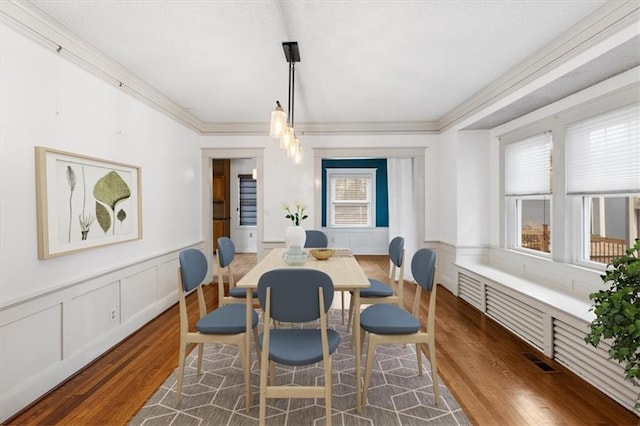 18 W 61st Ter, Kansas City, MO 64113 - dining space with wood finished floors, plenty of natural light, wainscoting, ornamental molding, and a decorative wall