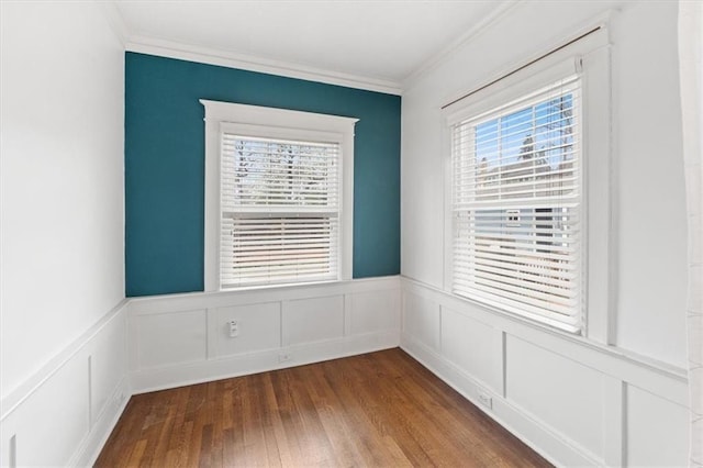 18 W 61st Ter, Kansas City, MO 64113 - unfurnished room featuring healthy amount of natural light, crown molding, a wainscoted wall, dark wood finished floors, and a decorative wall