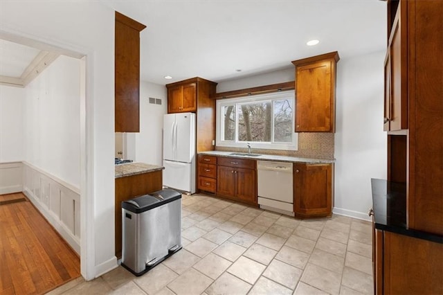 18 W 61st Ter, Kansas City, MO 64113 - kitchen featuring white appliances, a sink, backsplash, brown cabinets, and recessed lighting