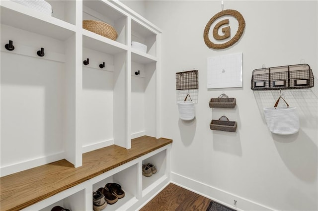 mudroom with dark wood finished floors and baseboards