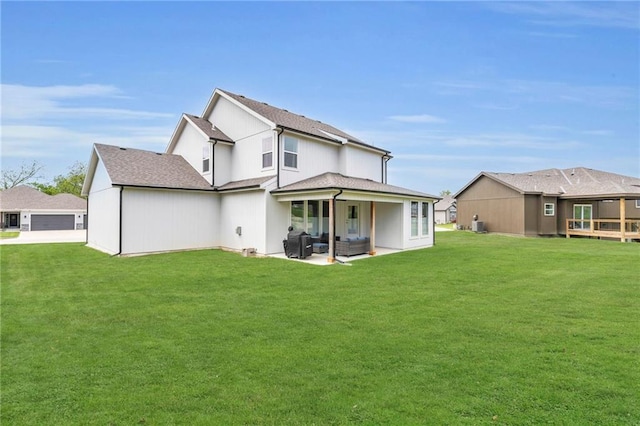 rear view of house featuring an outdoor hangout area, a yard, a garage, a patio area, and driveway