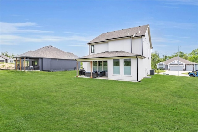 rear view of house featuring an outdoor living space, a lawn, cooling unit, and a shingled roof