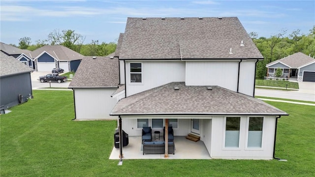 rear view of house featuring a patio, a lawn, and roof with shingles
