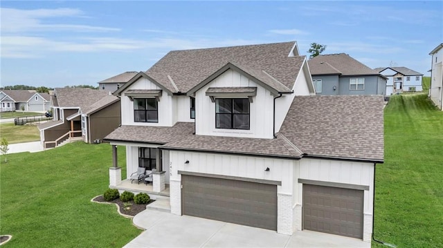 modern farmhouse with board and batten siding, a shingled roof, driveway, and a front yard