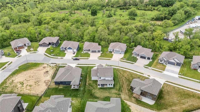 view of property location with nearby suburban area and a heavily wooded area