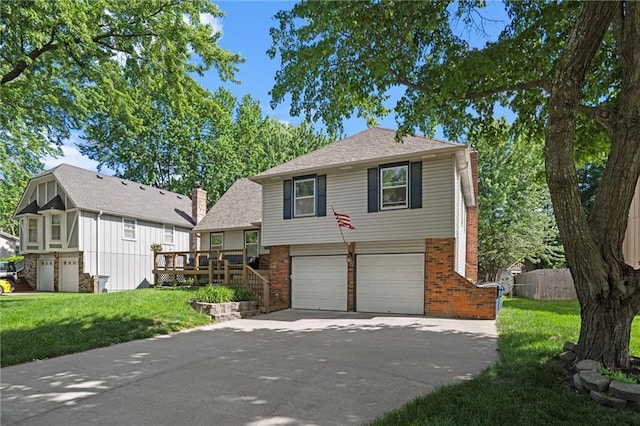 split level home featuring a chimney, brick siding, a garage, and concrete driveway