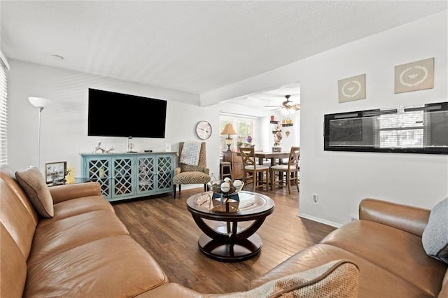 living room with wood finished floors, baseboards, and a ceiling fan