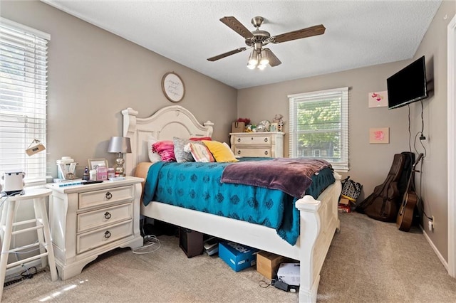 carpeted bedroom with a ceiling fan and a textured ceiling
