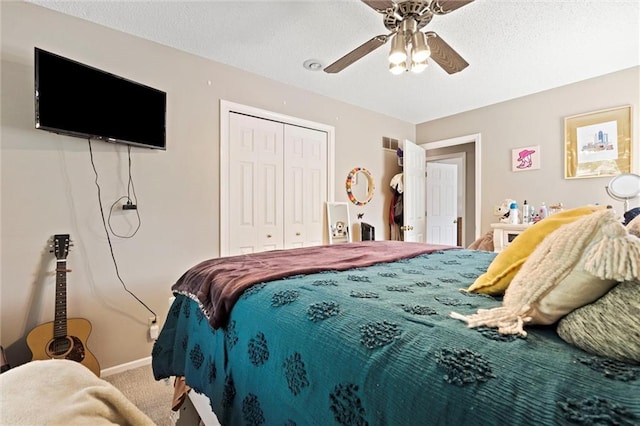 carpeted bedroom featuring a closet, a ceiling fan, baseboards, and a textured ceiling