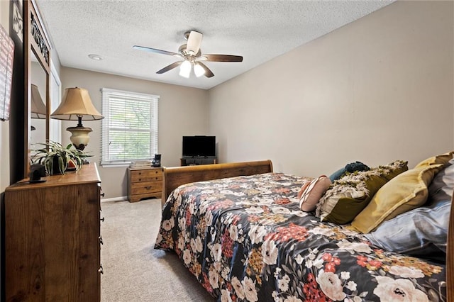bedroom featuring carpet flooring, a textured ceiling, ceiling fan, and baseboards