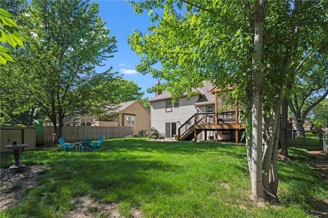 view of yard with stairs, a deck, and an outdoor fire pit
