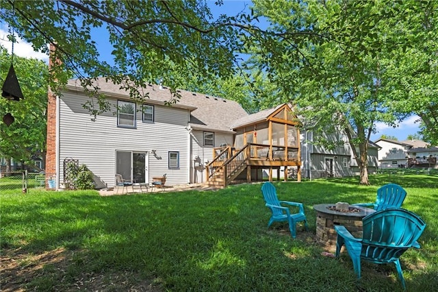 rear view of property with a sunroom, an outdoor fire pit, stairs, a patio area, and roof with shingles