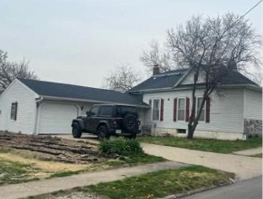 524 N Walnut St, Maryville, MO 64468 - view of side of home with an attached garage, a chimney, and driveway