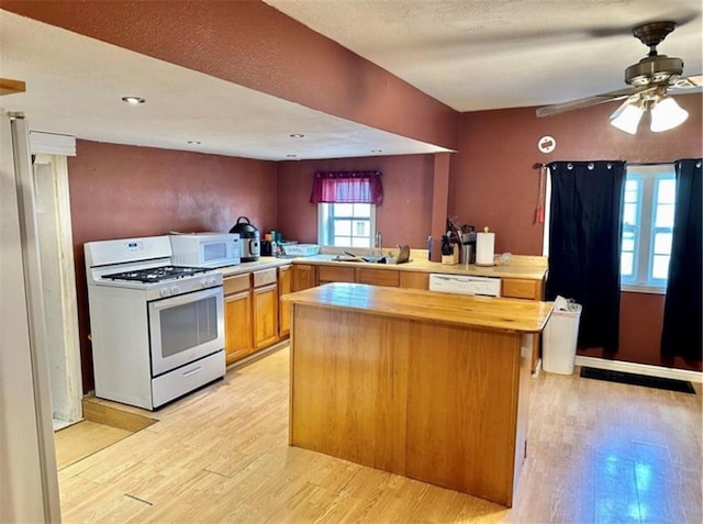 524 N Walnut St, Maryville, MO 64468 - kitchen featuring white appliances, light wood-type flooring, butcher block counters, and a kitchen island