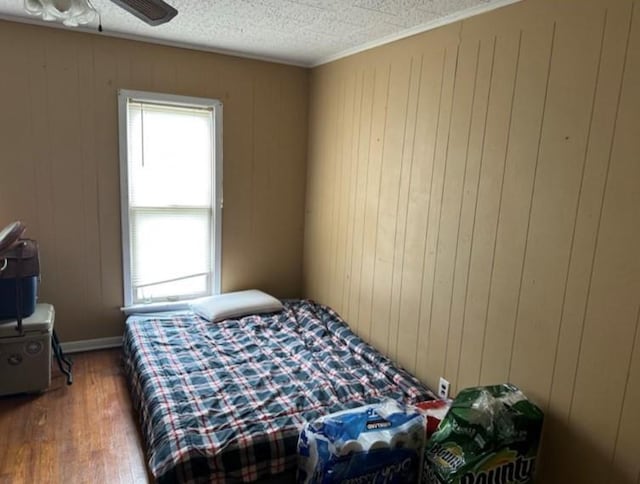 524 N Walnut St, Maryville, MO 64468 - bedroom featuring wood finished floors, a textured ceiling, and wood walls