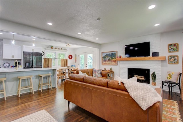 81 S Street S, St, Lake Lotawana, MO 64086 - living room featuring dark wood-style flooring, recessed lighting, a brick fireplace, and a textured ceiling