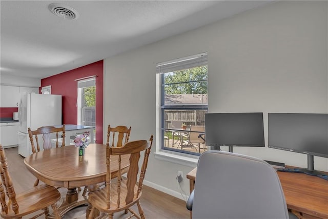 dining area with healthy amount of natural light, wood finished floors, a desk, and baseboards