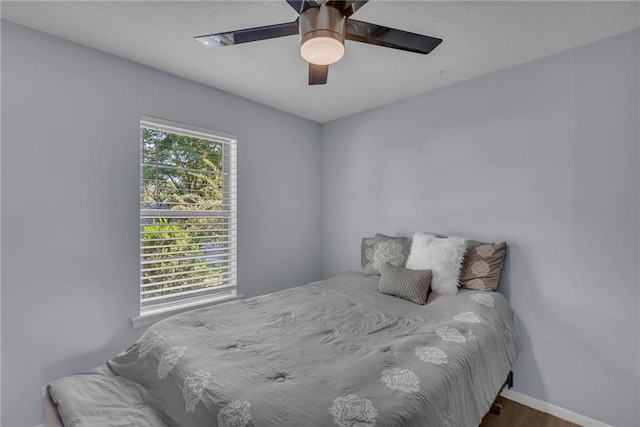 bedroom featuring wood finished floors, ceiling fan, and baseboards