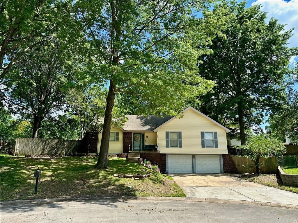 504 NW Brett Cir, Blue Springs, MO 64014 - view of front facade featuring a garage, concrete driveway, and brick siding