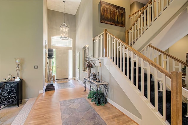 5445 NE Northgate Xing, Lees Summit, MO 64064 - foyer entrance with a towering ceiling, stairway, a chandelier, baseboards, and wood finished floors