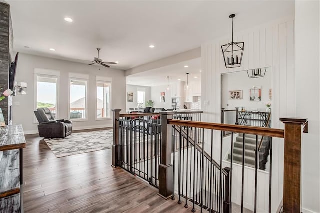 4713 NE Saratoga Ct, Lees Summit, MO 64064 - hall featuring an upstairs landing, wood finished floors, recessed lighting, and baseboards