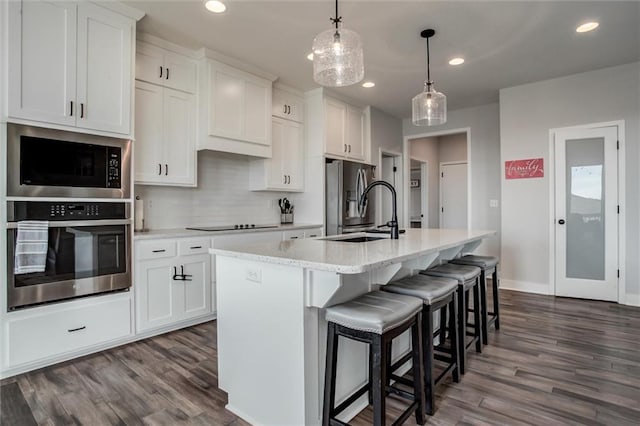 4713 NE Saratoga Ct, Lees Summit, MO 64064 - kitchen with stainless steel appliances, a sink, dark wood-style flooring, white cabinetry, and recessed lighting