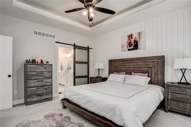 4713 NE Saratoga Ct, Lees Summit, MO 64064 - carpeted bedroom featuring a barn door, a raised ceiling, connected bathroom, and ceiling fan