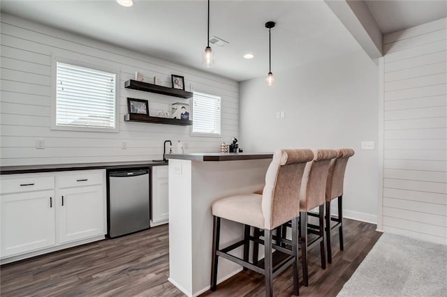 4713 NE Saratoga Ct, Lees Summit, MO 64064 - kitchen with a breakfast bar area, stainless steel dishwasher, dark wood-style floors, white cabinetry, and recessed lighting