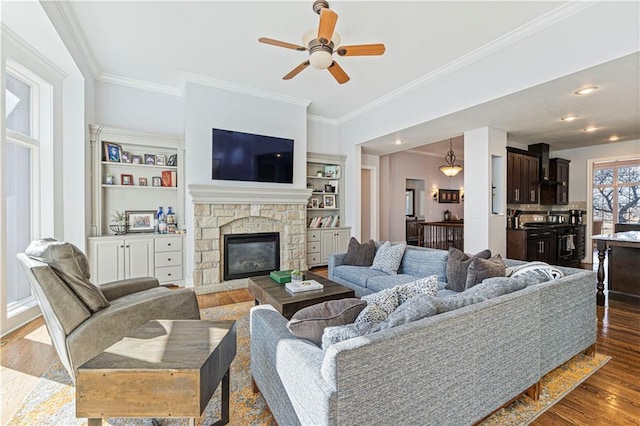 13123 W 54th Ter, Shawnee, KS 66216 - living area featuring crown molding, a ceiling fan, wood finished floors, and a stone fireplace
