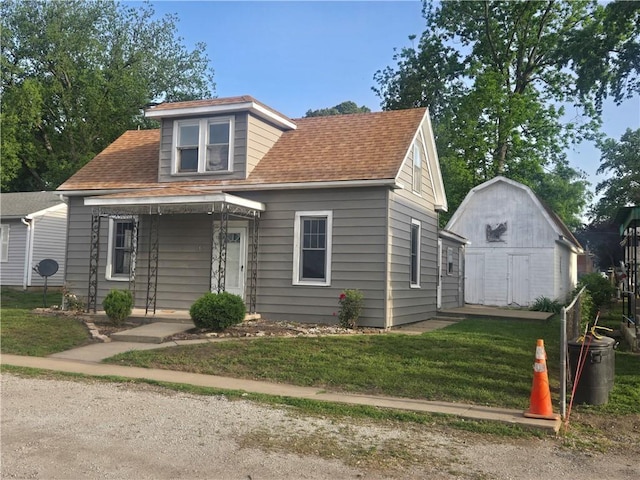 117 E Buford St, Wellington, MO 64097 - bungalow-style house with a front lawn, an outdoor structure, a shed, and roof with shingles