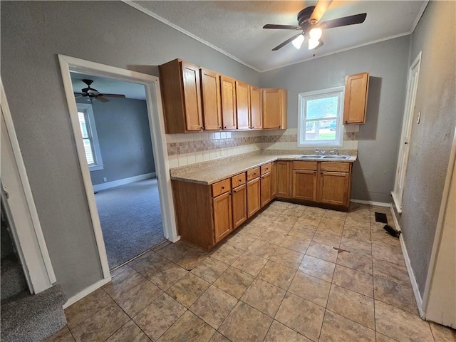 117 E Buford St, Wellington, MO 64097 - kitchen with ceiling fan, crown molding, baseboards, light countertops, and decorative backsplash