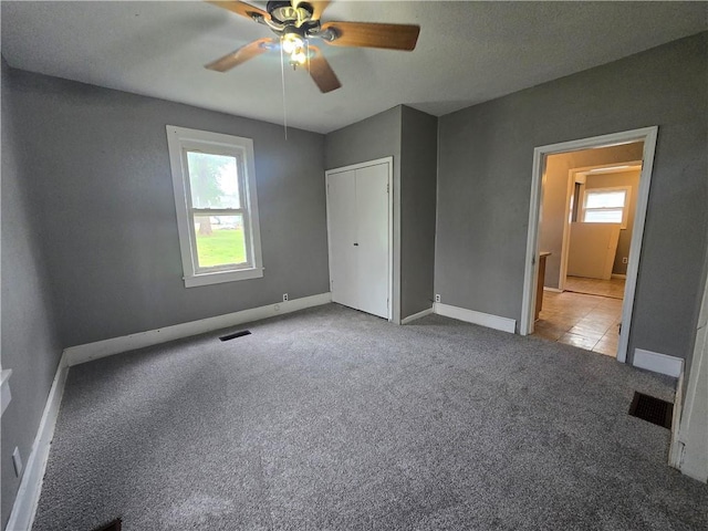 117 E Buford St, Wellington, MO 64097 - unfurnished bedroom featuring carpet, baseboards, ceiling fan, and a closet