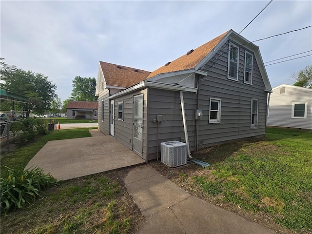 117 E Buford St, Wellington, MO 64097 - view of home's exterior with cooling unit, a patio area, and a lawn