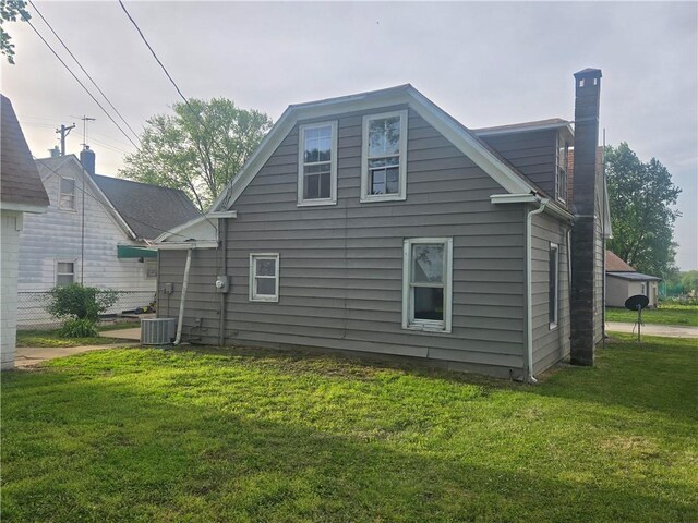 117 E Buford St, Wellington, MO 64097 - rear view of property with a chimney, a yard, and central air condition unit
