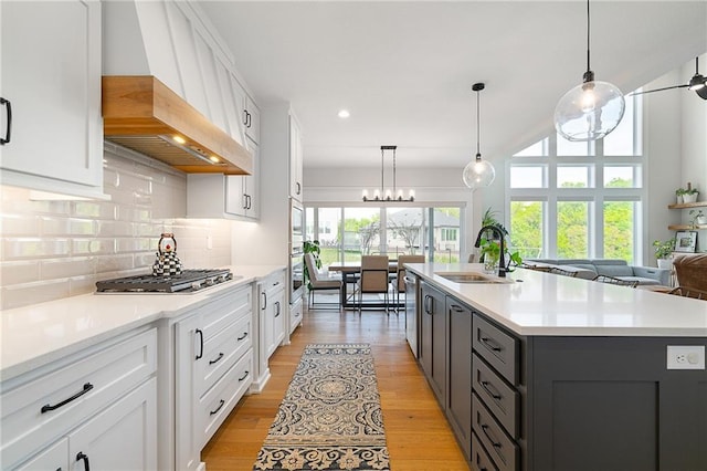 2705 NE Crestview St, Blue Springs, MO 64029 - kitchen with a sink, stainless steel appliances, light countertops, white cabinetry, and backsplash
