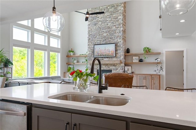 2705 NE Crestview St, Blue Springs, MO 64029 - kitchen with a sink, open floor plan, a stone fireplace, light countertops, and pendant lighting