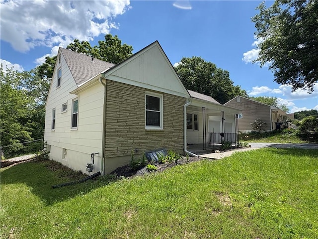 7115 Myrtle Ave, Kansas City, MO 64132 - rear view of property with stone siding, a yard, a porch, and a shingled roof