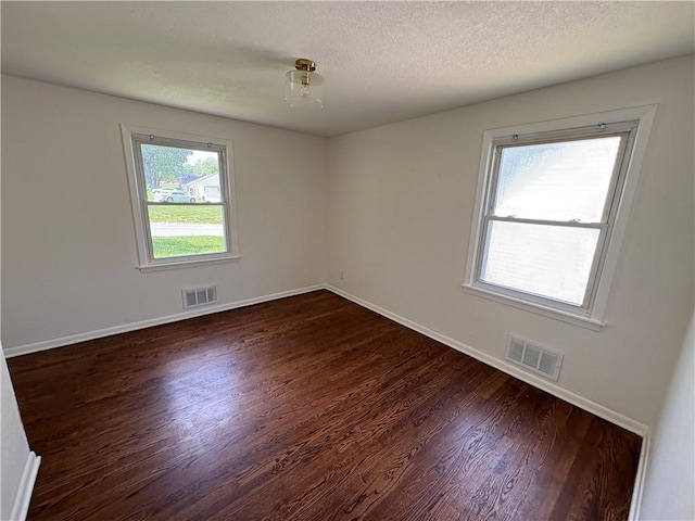 7115 Myrtle Ave, Kansas City, MO 64132 - empty room featuring dark wood-type flooring, baseboards, and a textured ceiling