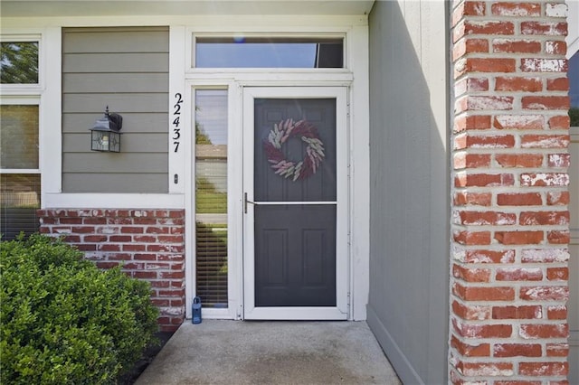 property entrance featuring brick siding